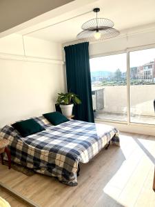 a bedroom with a bed and a large window at Le sud plage et piscine in Gassin