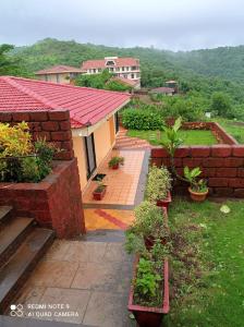 ein Haus mit einem Garten mit Pflanzen darin in der Unterkunft Redstone Hills, Diveagar in Diveagar