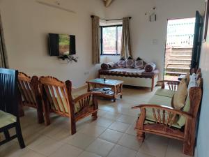a living room with wooden chairs and a couch at Redstone Hills, Diveagar in Diveagar