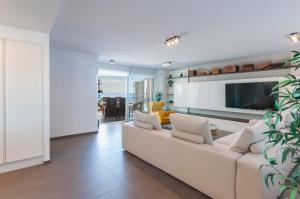 sala de estar con sofá blanco y TV en AG Los Carmenes Premium, en Playa de Gandía