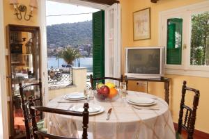 a table with a bowl of fruit and a television at Villa Pergantini in Ayia Evfimia