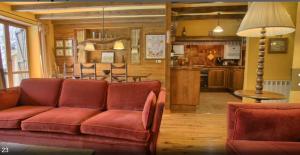 a living room with a red couch and a kitchen at Apartamento Rincon del cielo in Benasque
