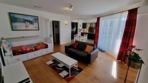 sala de estar con sofá y silla en Geräumiges und Modernes Apartment Tara am Meer mit Parkplatz!, en Zandvoort