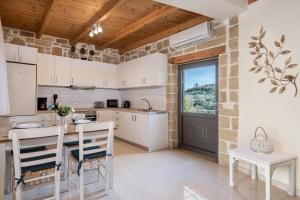 une cuisine avec des armoires blanches et une table et des chaises dans l'établissement Villa Vanka, à La Canée
