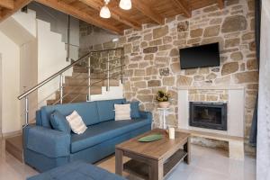 un salon avec un canapé bleu et une cheminée dans l'établissement Villa Vanka, à La Canée