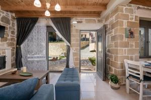 un salon avec des meubles bleus et un mur en pierre dans l'établissement Villa Vanka, à La Canée