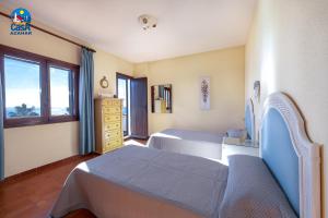 a bedroom with two beds and a dresser and a window at Apartamentos Ibiza Casa Azahar in Alcossebre