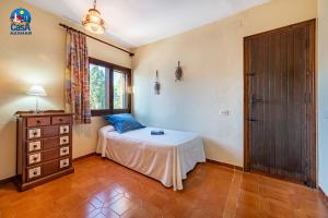 sypialnia z łóżkiem, komodą i oknem w obiekcie Apartamentos Ibiza Casa Azahar w mieście Alcossebre