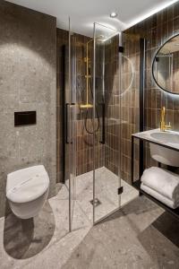 a bathroom with a toilet, sink, and shower stall at Boutique Hotel First City in The Hague