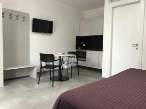 1 dormitorio con mesa, silla y TV en Residence Candeloro, en Francavilla al Mare