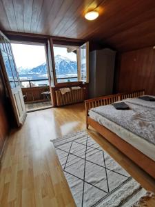een slaapkamer met een bed en een groot raam bij Chalet Edelweiss Sigriswil in Sigriswil