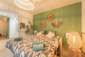 a bedroom with a bed and a green wall at Le Med - Apartment T2 Confort - Proche plage - Clim - Parking privé in La Ciotat