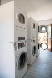 a laundry room with three washers and a dryer at Aphrodite Family Eco Camping in Neo Chorio