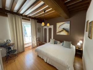 a bedroom with a bed and a table and a window at Fleurs de Vignes Piscine in Montagny-lès-Beaune