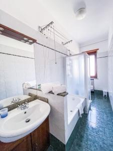 Baño blanco con bañera y lavamanos en MYHOUSE INN TOGLIATTI - Affitti Brevi Italia, en Collegno