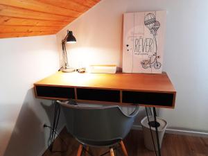 a desk with a chair and a lamp on top of it at ⁂⁂ GITE LE PRES AU CERF [CLEDICIHOME] 2 steps from the LISPACH resort // PRIVATE toboggan run! SNOWSHOE DEPARTURE ⁂⁂ in La Bresse
