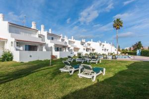 a group of lawn chairs in front of a building at Oura Parque Apartamentos Turisticos in Albufeira