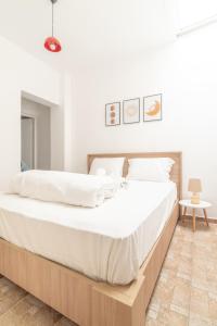 een slaapkamer met een groot bed met witte lakens bij 1 BedRoom Apartment Opposite Medical Center in Heraklion