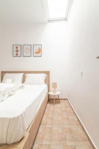 a white bedroom with a bed and a table at 1 BedRoom Apartment Opposite Medical Center in Heraklio Town