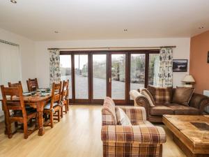 uma sala de estar com uma mesa e um sofá em The Lodge em Merthyr Tydfil