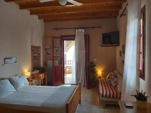 a bedroom with a bed and a couch and a window at Almyra apt in Mani in Kotrónion