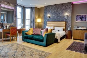 a bedroom with a bed and a green couch at Halvard Hotel in Douglas
