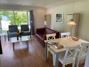 uma sala de estar com um sofá e uma mesa em Nice chalet, covered terrace and in nature reserve em Elst
