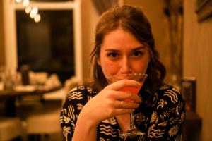 Una donna sta tenendo un drink in mano a un bicchiere di Halvard Hotel a Douglas