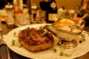 a white plate with a piece of meat with a sauce at Halvard Hotel in Douglas