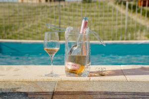 a bottle of wine and a glass next to a pool at Bricco Rosso in Farigliano