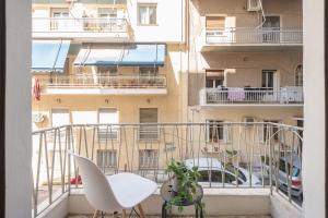 a balcony with a white table and chairs and a building at Erythros Boutique Suite By Cloudkeys in Athens