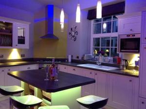 a kitchen with white cabinets and a black counter top at Stylish & Contemporary 5 * Fully Renovated Luxurious Holiday Cottage Ambleside in Ambleside