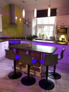 a purple kitchen with a table and chairs at Stylish & Contemporary 5 * Fully Renovated Luxurious Holiday Cottage Ambleside in Ambleside
