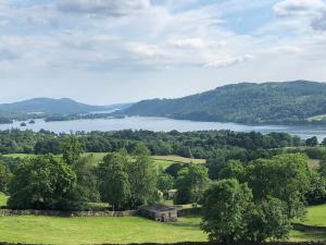 a view of a lake in the middle of a field at Stylish & Contemporary 5 * Fully Renovated Luxurious Holiday Cottage Ambleside in Ambleside