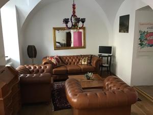 a living room with brown leather couches and a table at Wienerstrasse 3 in Gumpoldskirchen