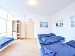 SSW Grand Hostel Iława في ايوافا: غرفة بسريرين وبها وسائد زرقاء