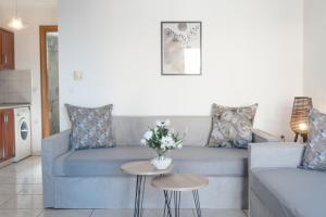 un soggiorno con divano blu e tavolo di Mouses Apartments a Limenas