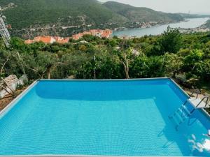 - une piscine bleue avec vue sur la montagne dans l'établissement Cottage Ciara, à Mokošica
