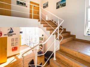 una escalera en una casa con suelo de madera y barandillas blancas en SSW Grand Hostel Iława, en Iława