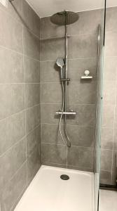 a shower with a glass door in a bathroom at Le Golf Balnéo - Cosy & SPA - Appartement in Saint-Étienne