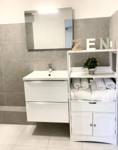 a white bathroom with a sink and a mirror at Le Golf Balnéo - Cosy & SPA in Saint-Étienne