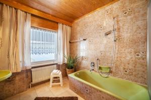 a bathroom with a green tub and a window at Residence Pichler Apartment 1 in San Leonardo in Passiria +24 photos