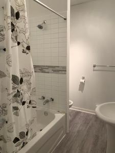 a bathroom with a shower curtain and a tub and a sink at Gestion clin d Oeil 349 in La Tuque