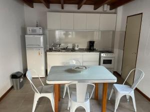 cocina con mesa, sillas y nevera en Valle de Uco. Departamento 2 habitaciones 4 huéspedes. en Tunuyán