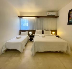 A bed or beds in a room at Delphin Beach Hotel