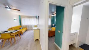 a living room with a table and a dining room at Apartamentos Eldorado in Lloret de Mar