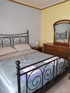 um quarto com uma cama com um espelho e uma cómoda em Appartamento mare blu Pachino em Pachino