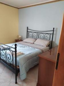 a bedroom with a large bed with a black frame at Appartamento mare blu Pachino in Pachino