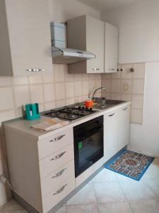 uma cozinha com uma placa de fogão e forno. em Appartamento mare blu Pachino em Pachino