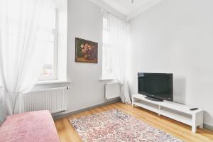 sala de estar blanca con TV de pantalla plana en New and Lovely Apartament in Vilnius City Centre en Vilna